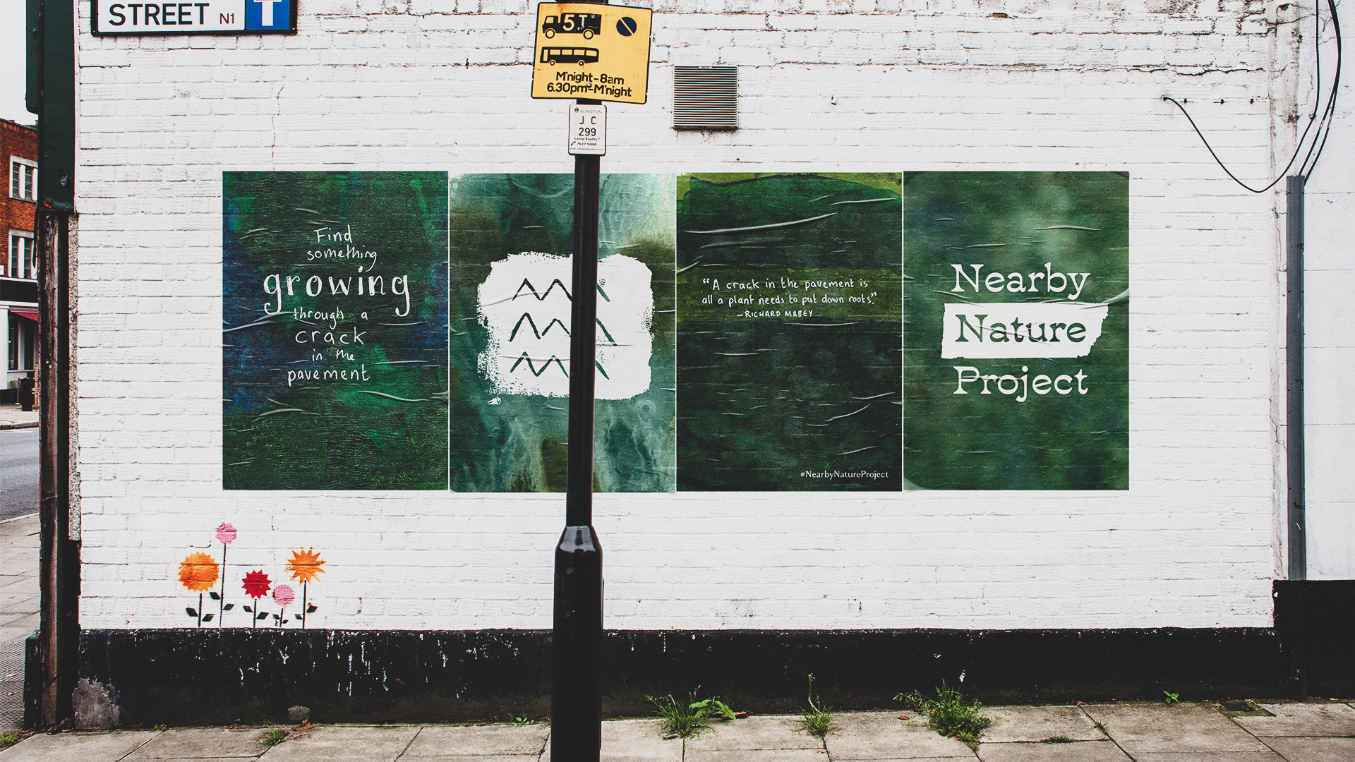 4 wheat paste posters on a brick wall, each showing a different image from the project.