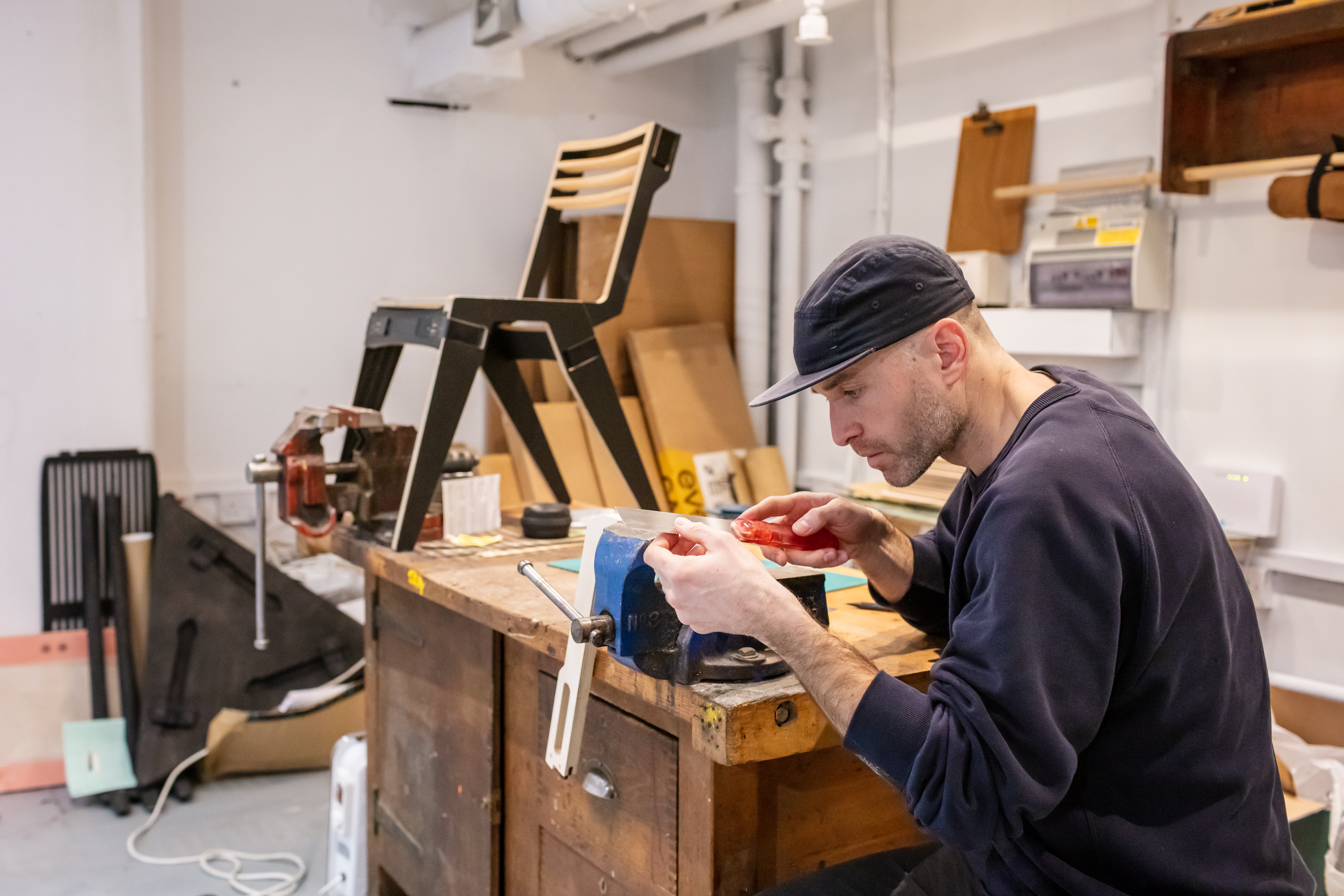 Oliver from FUZL Furniture works at this bench with a handmade chair behind him