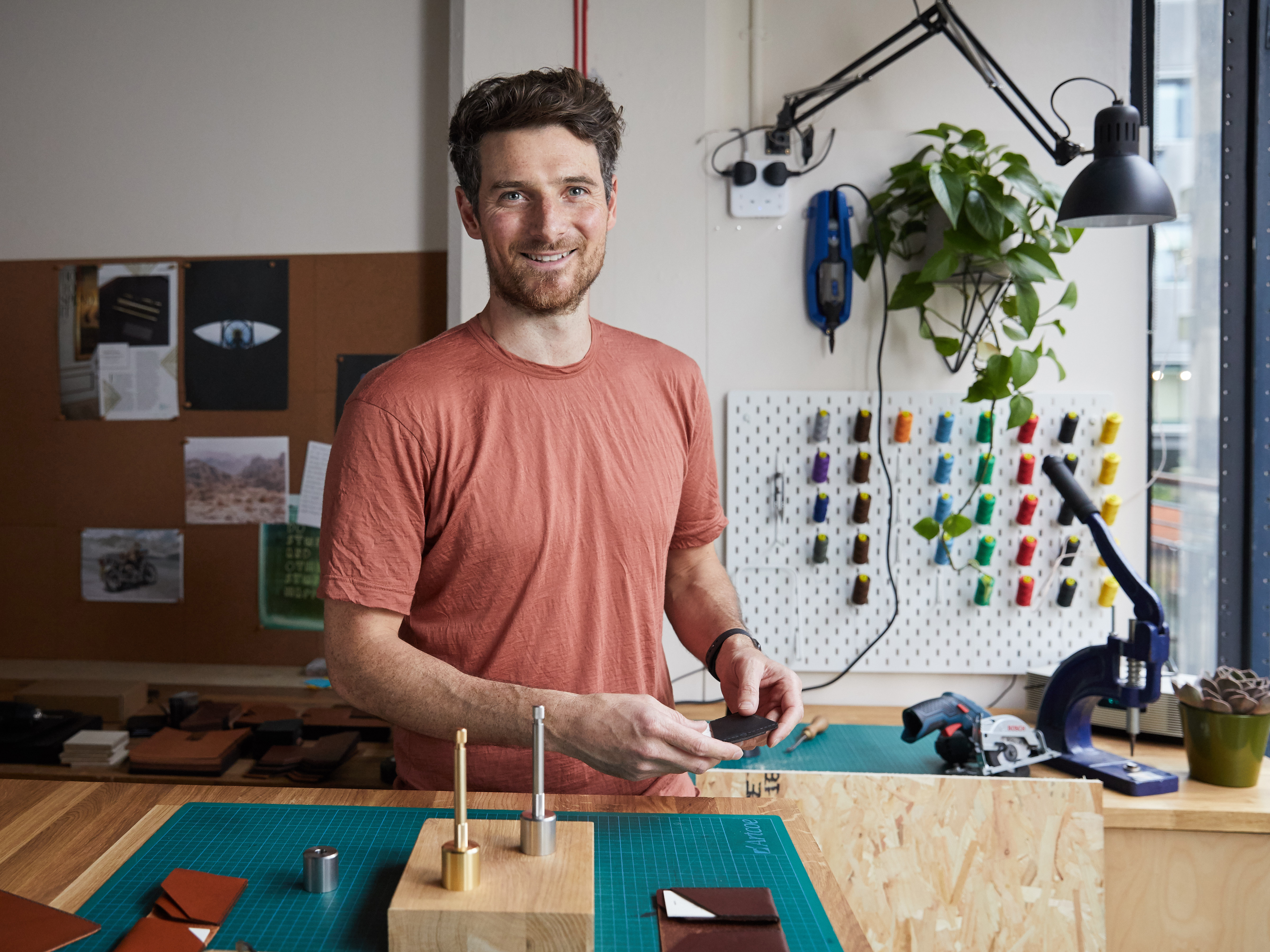 Alasdair from Wingback standing in his workshop at Oxo Tower Wharf surrounded by materials and tools