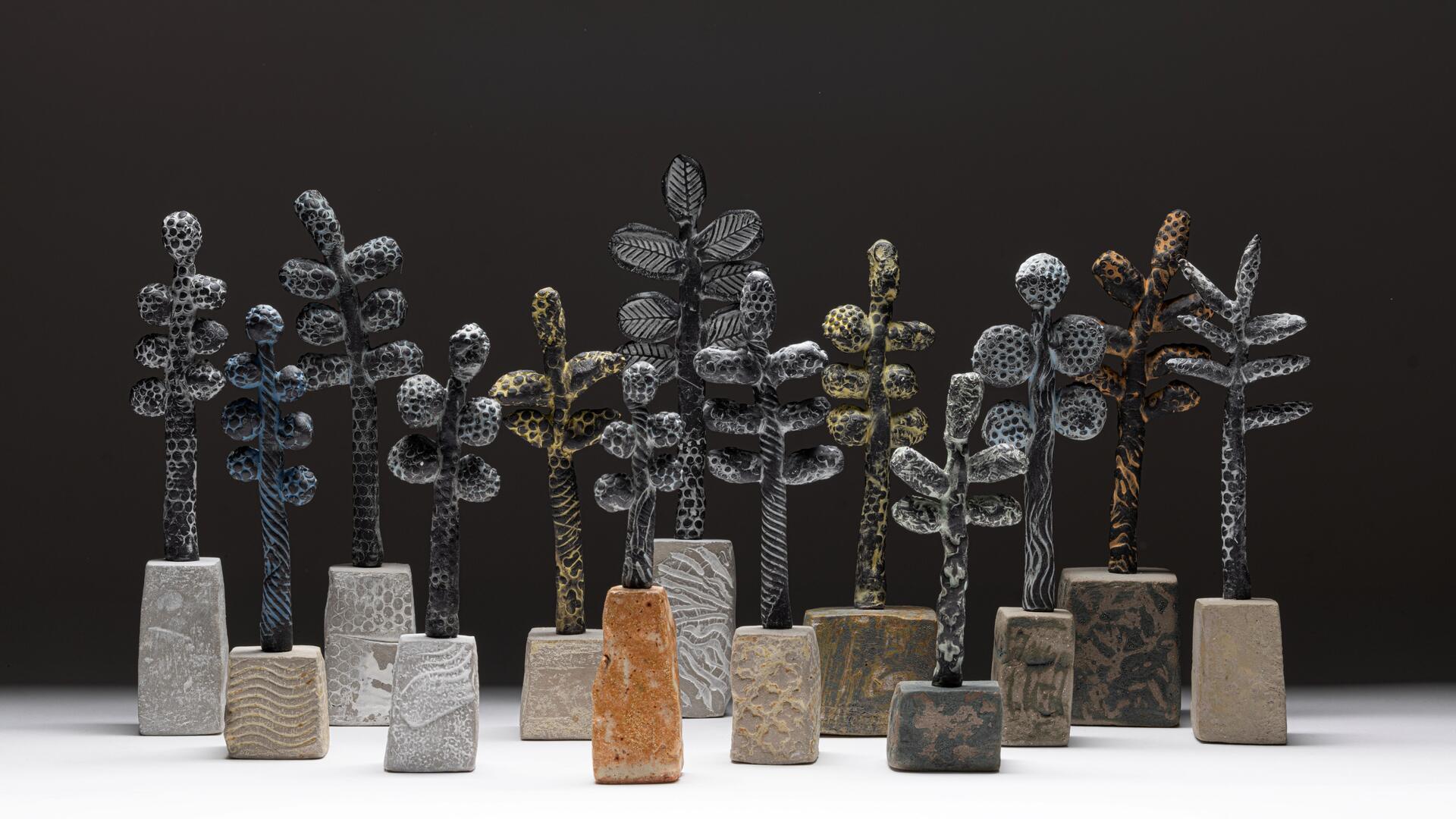 A group of stylised ceramic trees with heavily textured surfaces