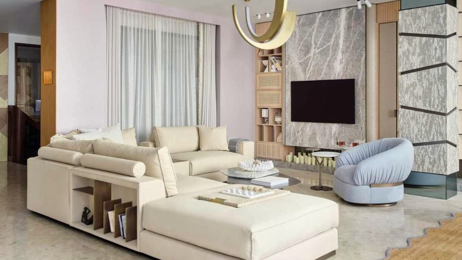 Interior of the FAURA showroom with a cream sofa, blue armchair, sculptural lighting and natural stone feature wall.