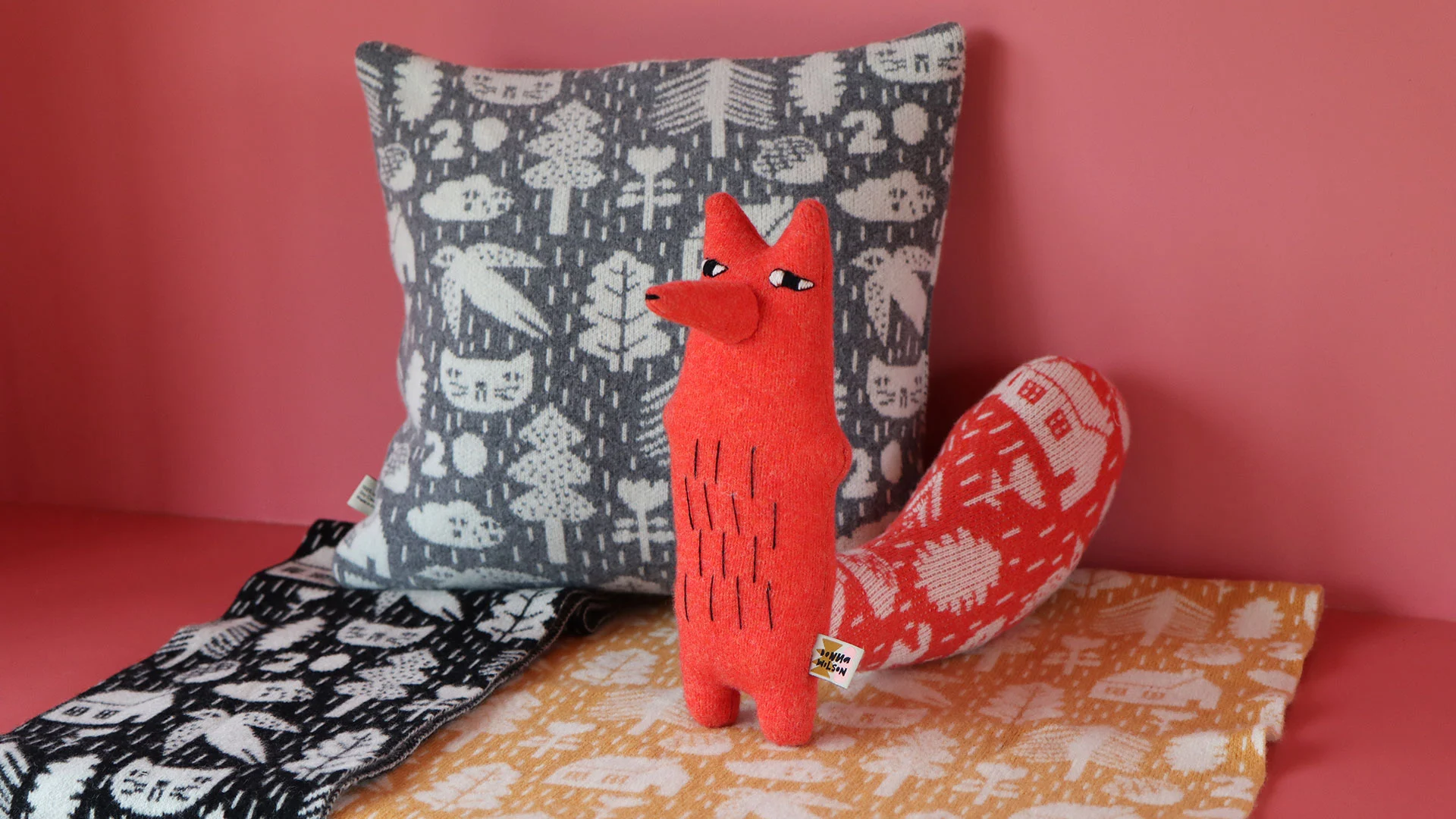 A collection of knitted products, including Cyril Squirrel Fox, decorated with Donna's anniversary motif.