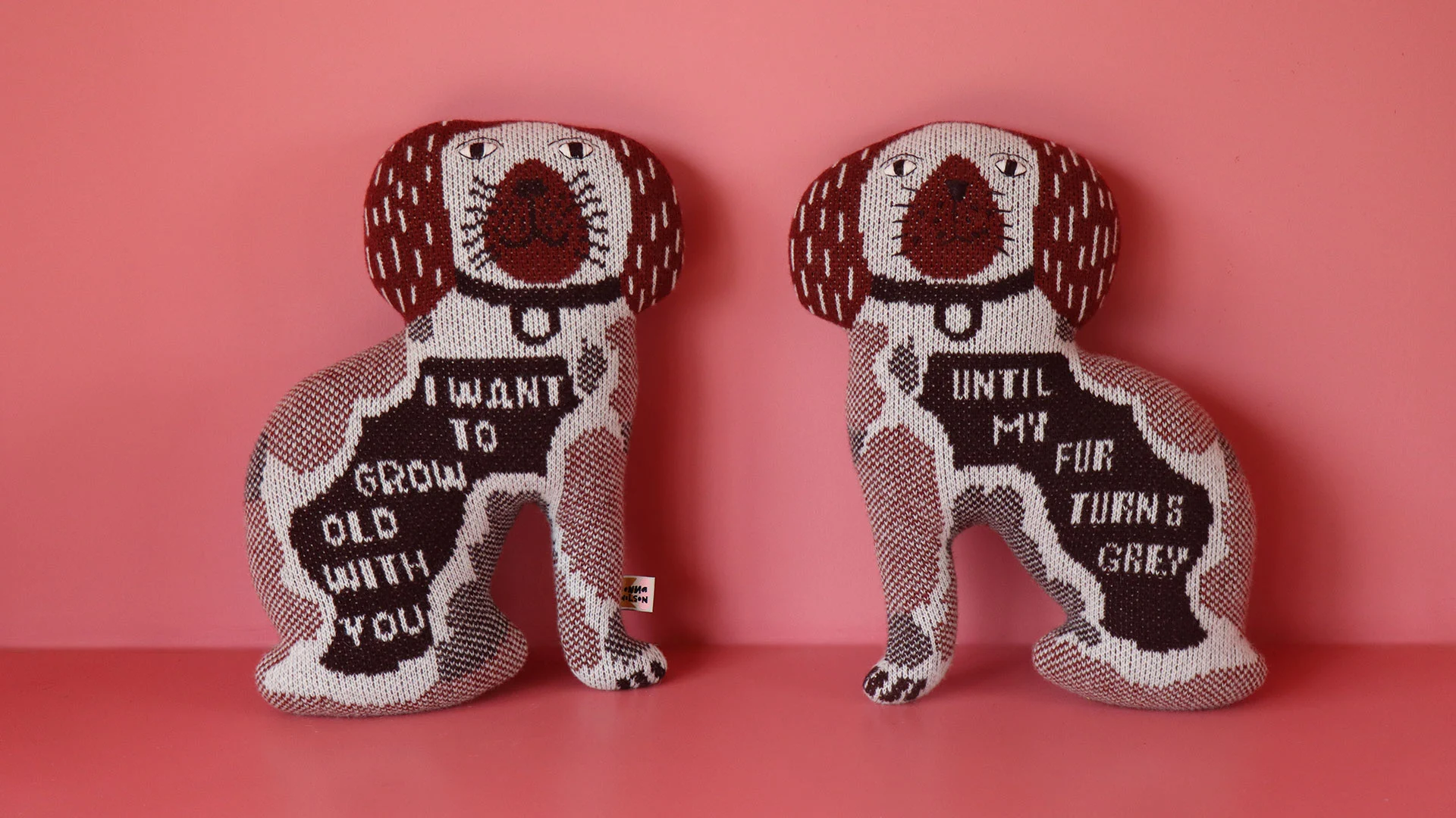A pair of knitted Staffordshire dogs, decorated with the text 'I want to grow old with you until my fur turns grey'.