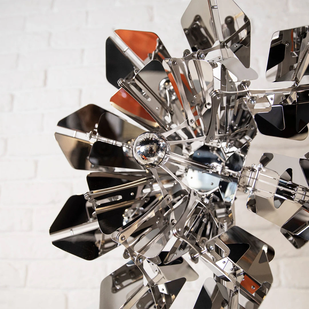 A futuristic metal flower unfurls, reflecting its environment in the highly polished surface 