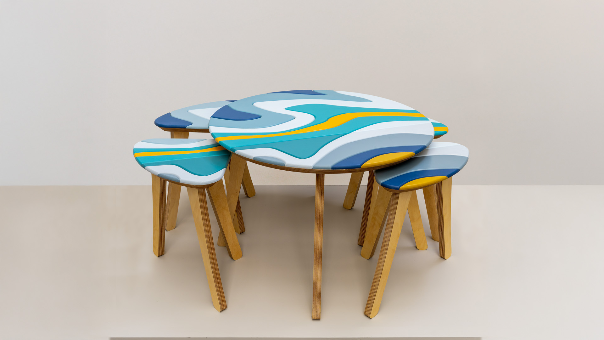 Together pairs a low circular table with four matching stools, each finished in hand-painted colour schemes. 