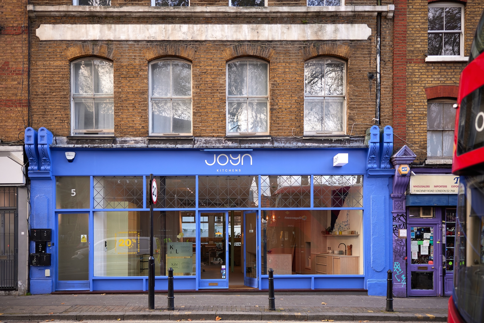 A wide exterior shot shows "Joyn Kitchens," a storefront with a bright blue facade 