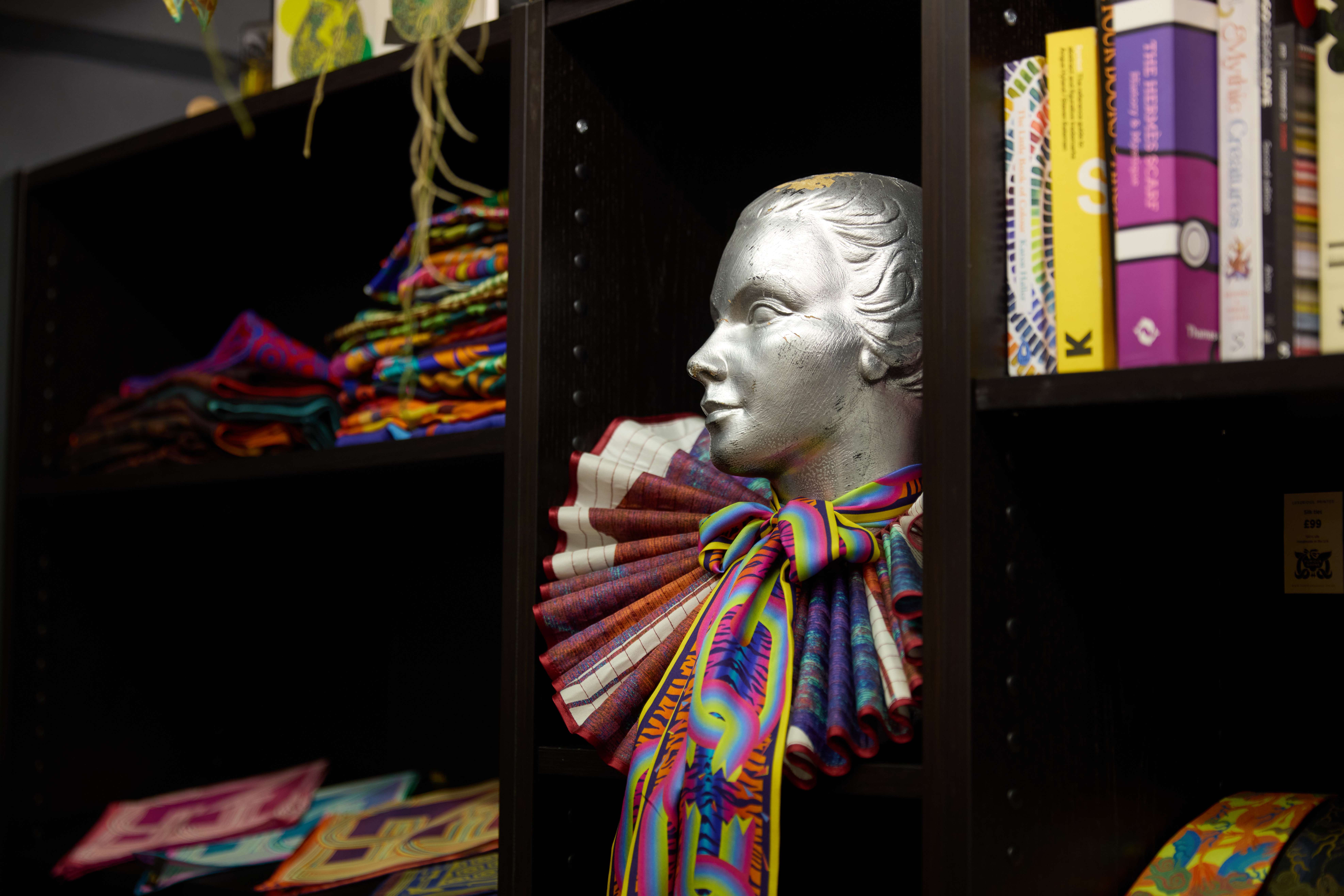 Image of a mannequin wearing a scarf in a shop.
