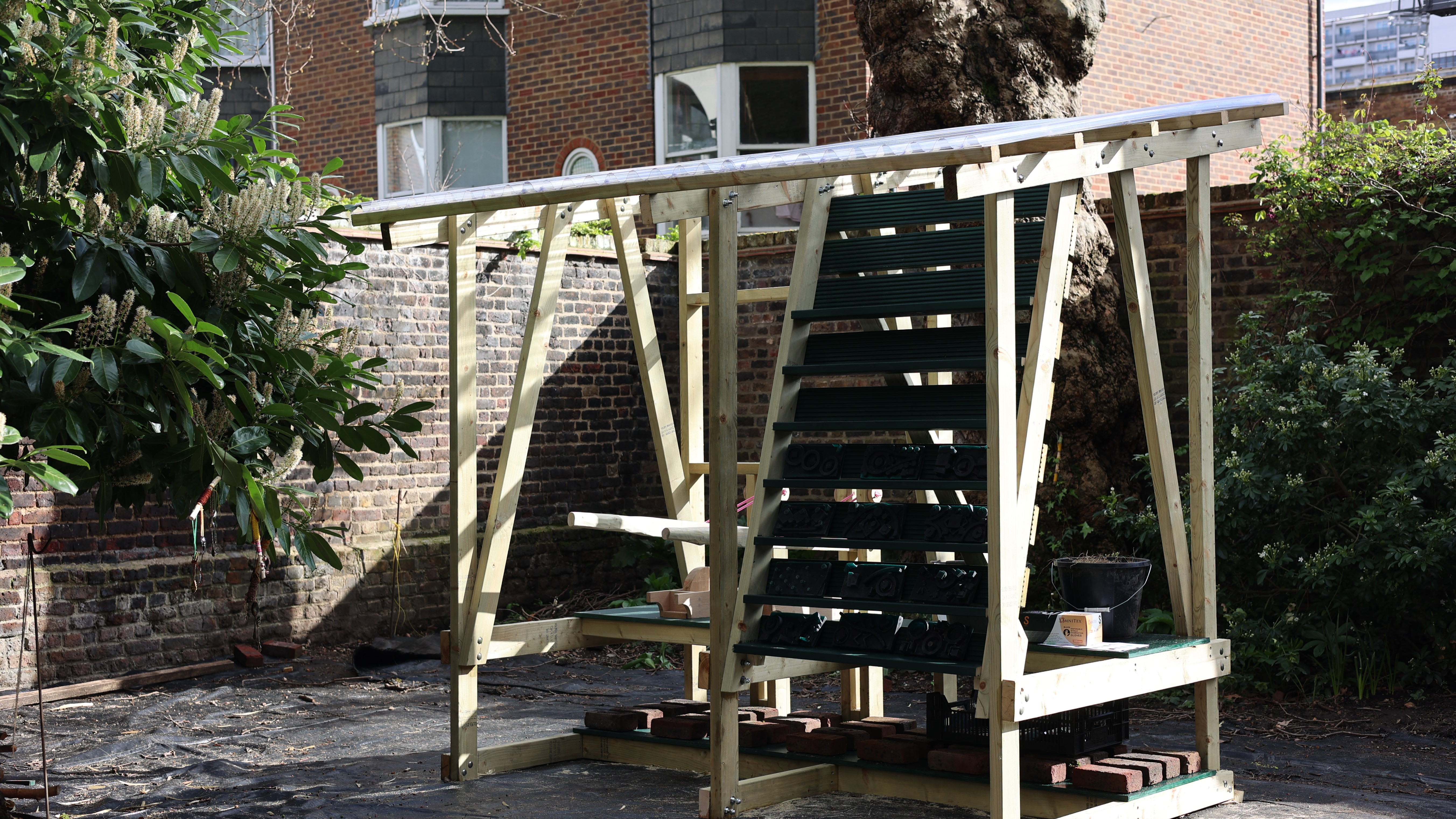 A wooden structure with shelves in the middle of a walled garden