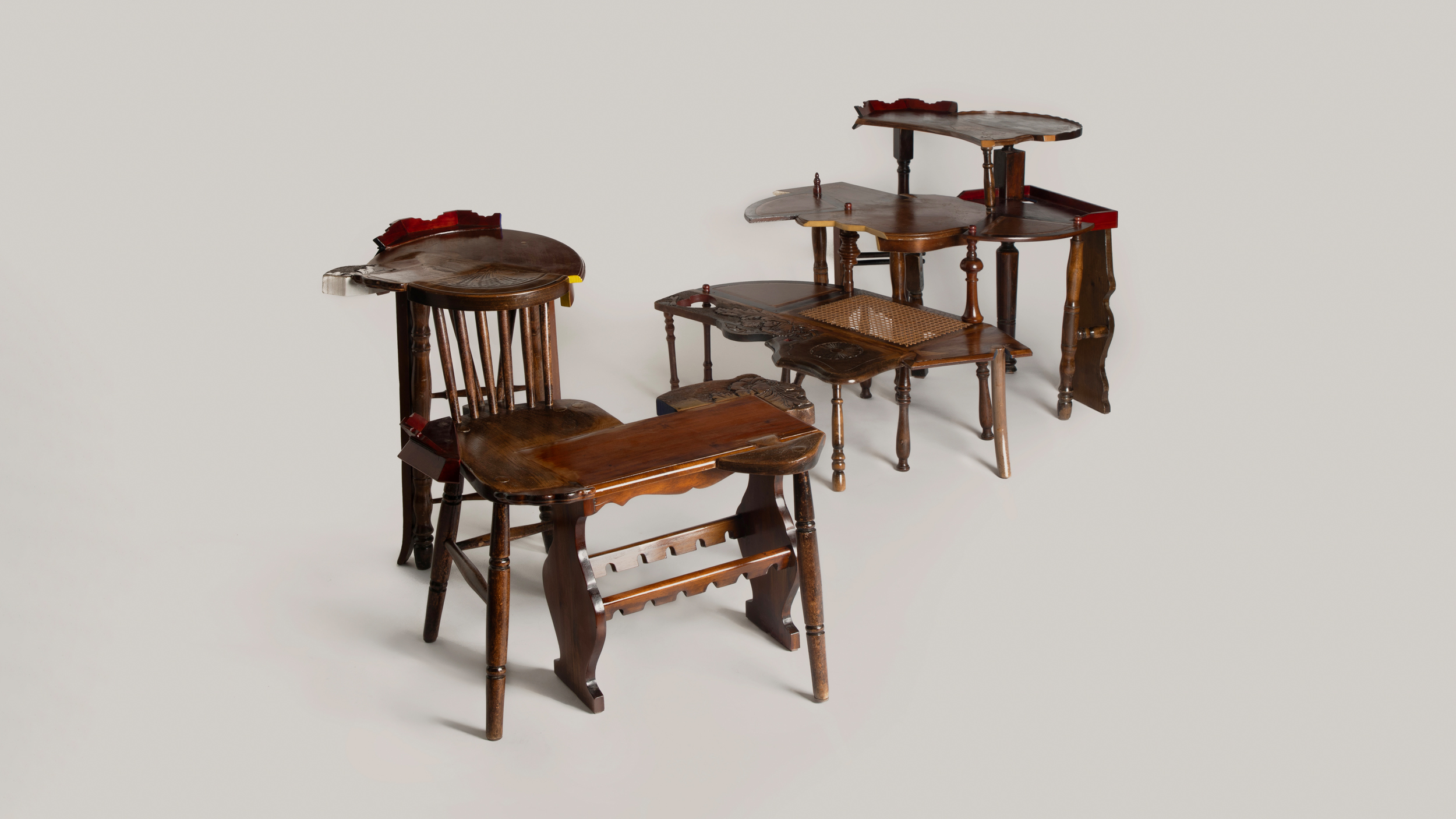 Sculptural furniture made from assembled vintage wooden chairs and tables, creating unique hybrid seating forms.