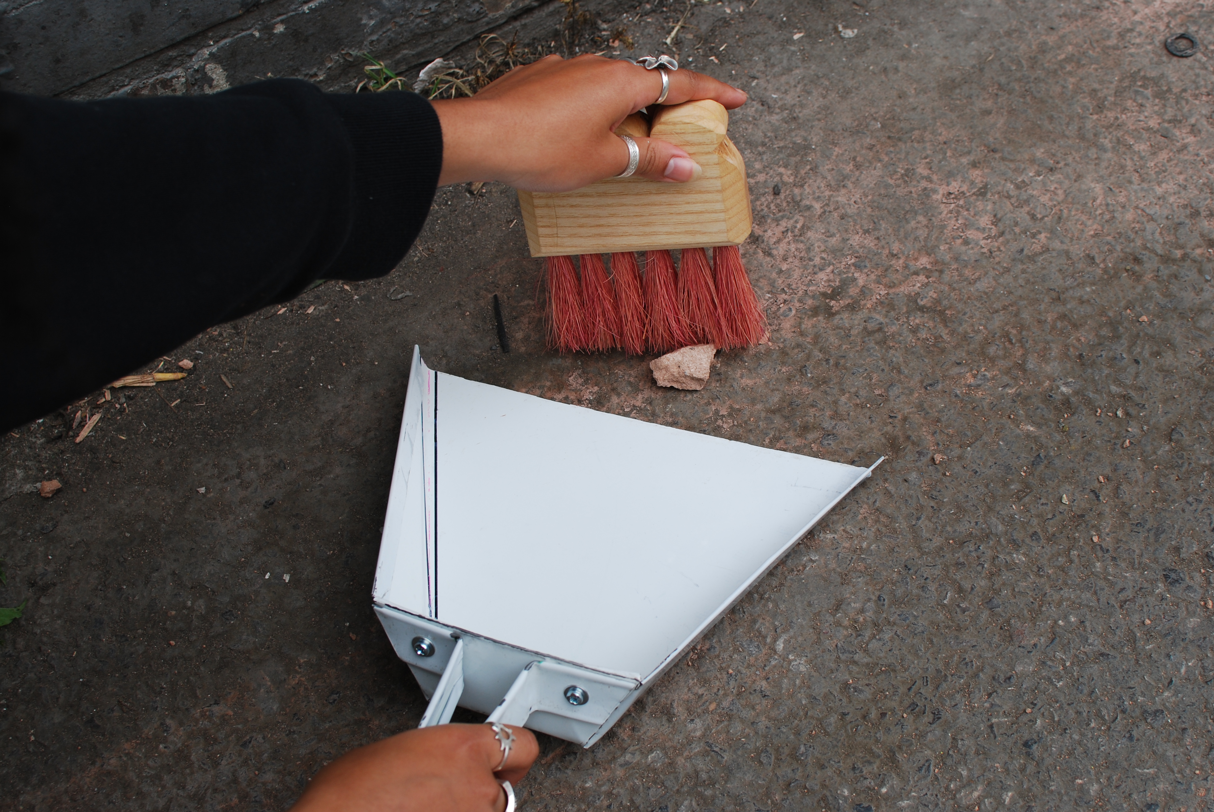 A participant uses the new dustpan and brush to sweep up some rubbish.
