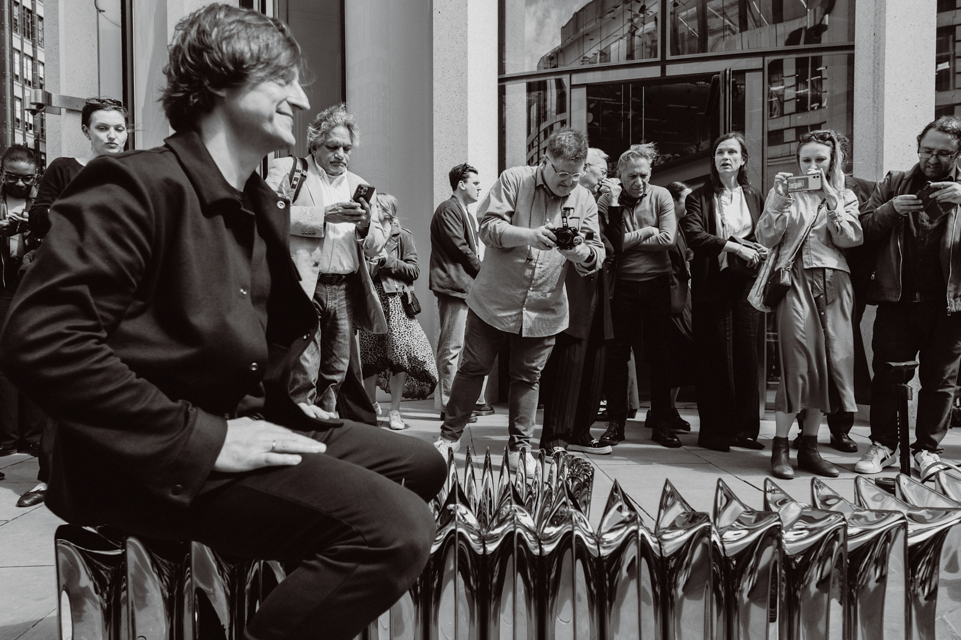 Artist Oskar Zieta sits on his inflated metal sculpture 'Whispers' on Ludgate Hill in the Fleet Street Quarter