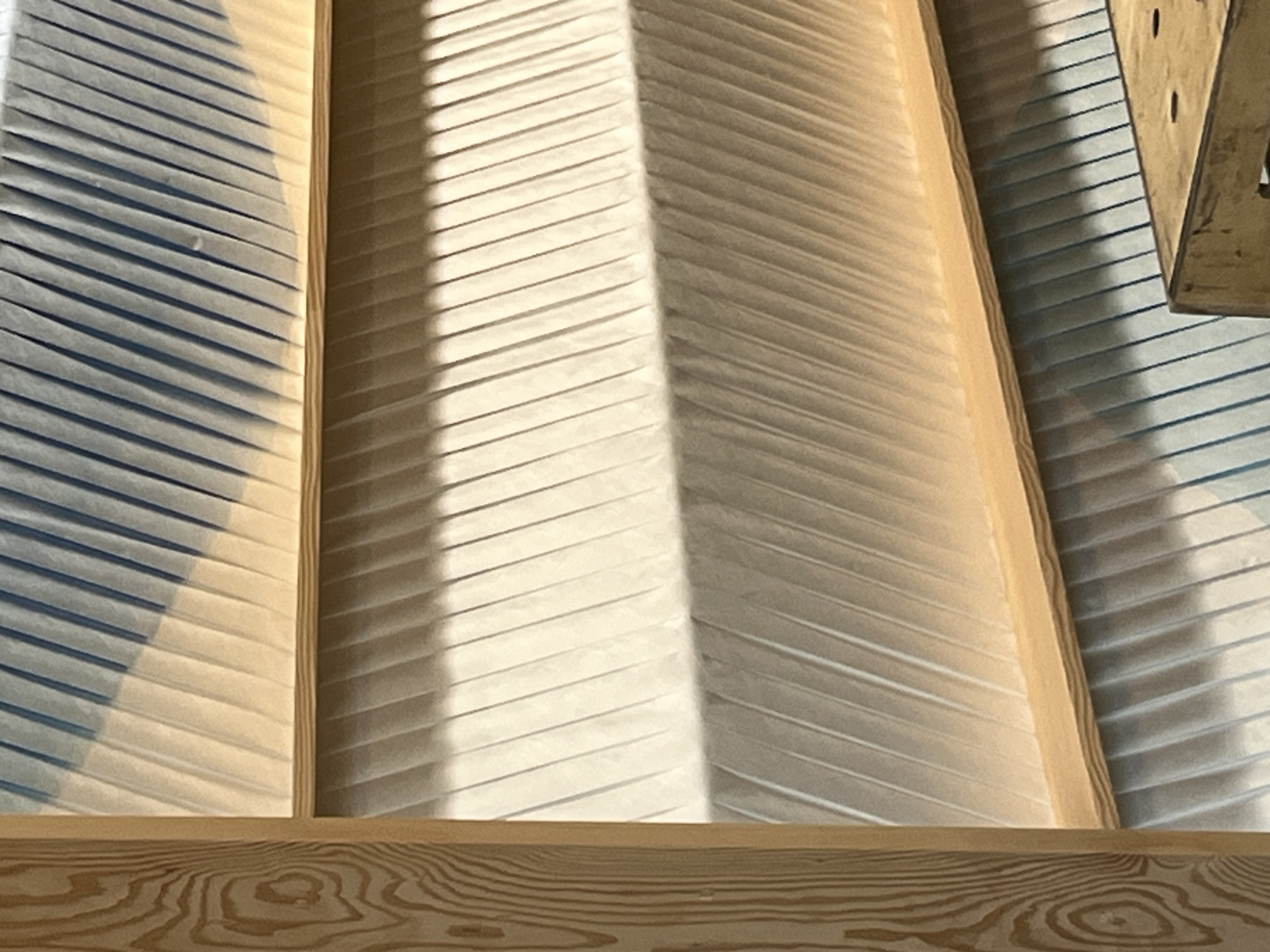 A close up of a blue and white art work panel showing the folds and corrugation of the stretched tyvek material