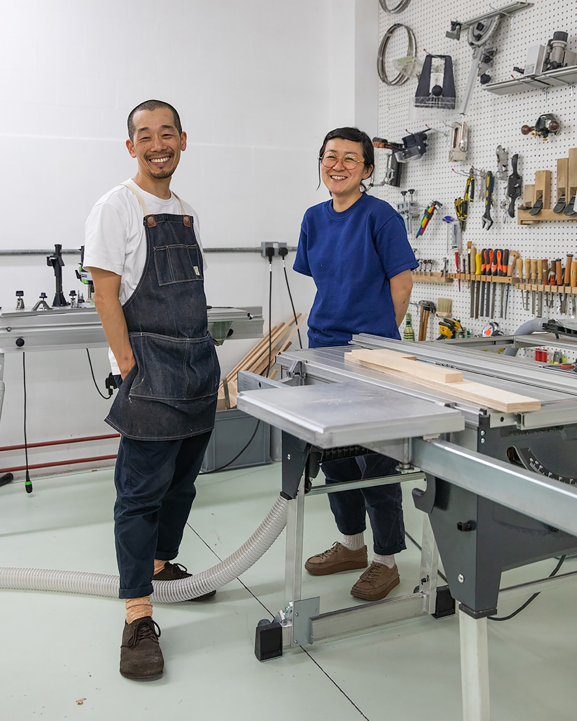 Two people stranding in a fabrication workshop smiling
