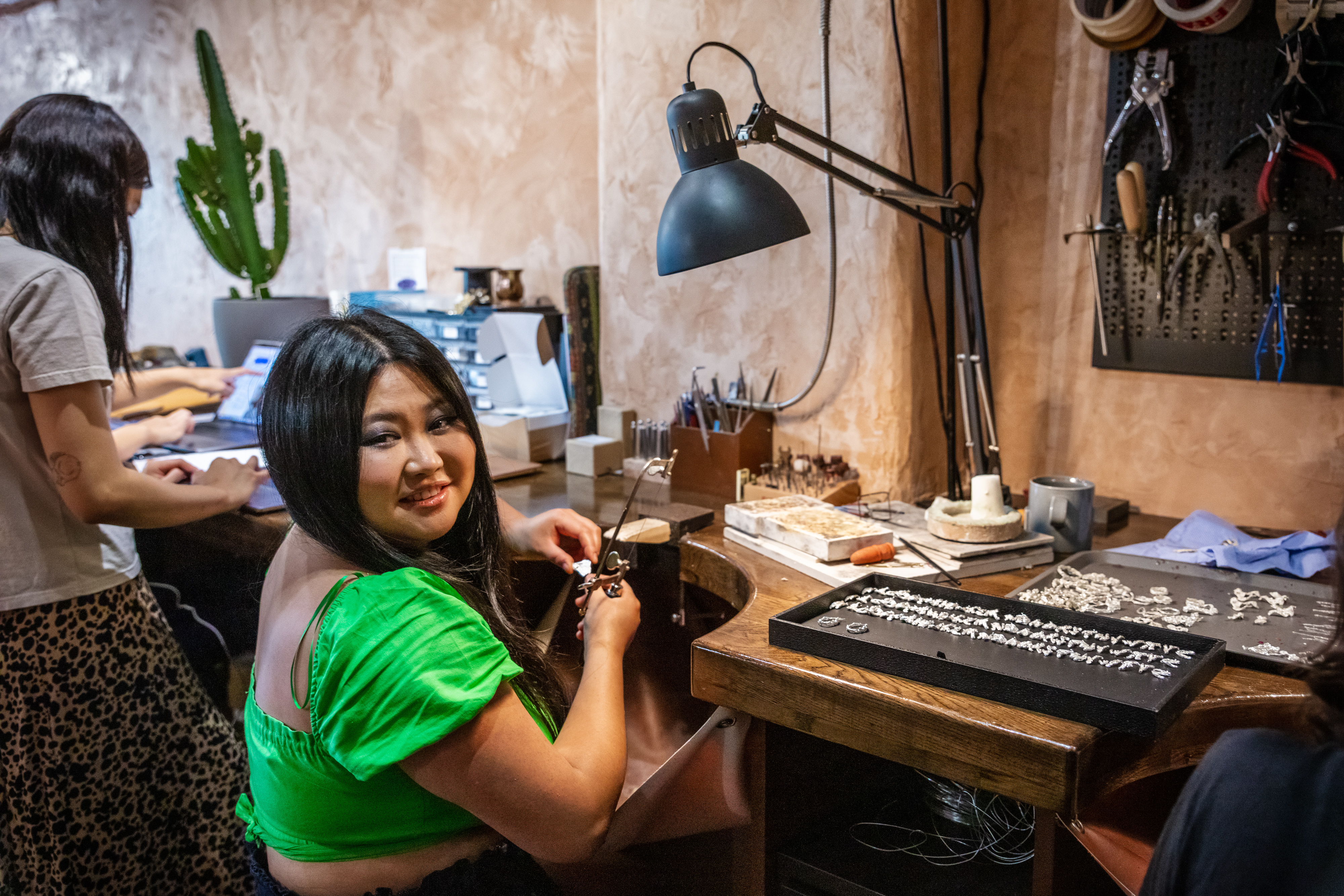 Loveness of Loveness Lee jewellery smiles while working ath her jewellery bench